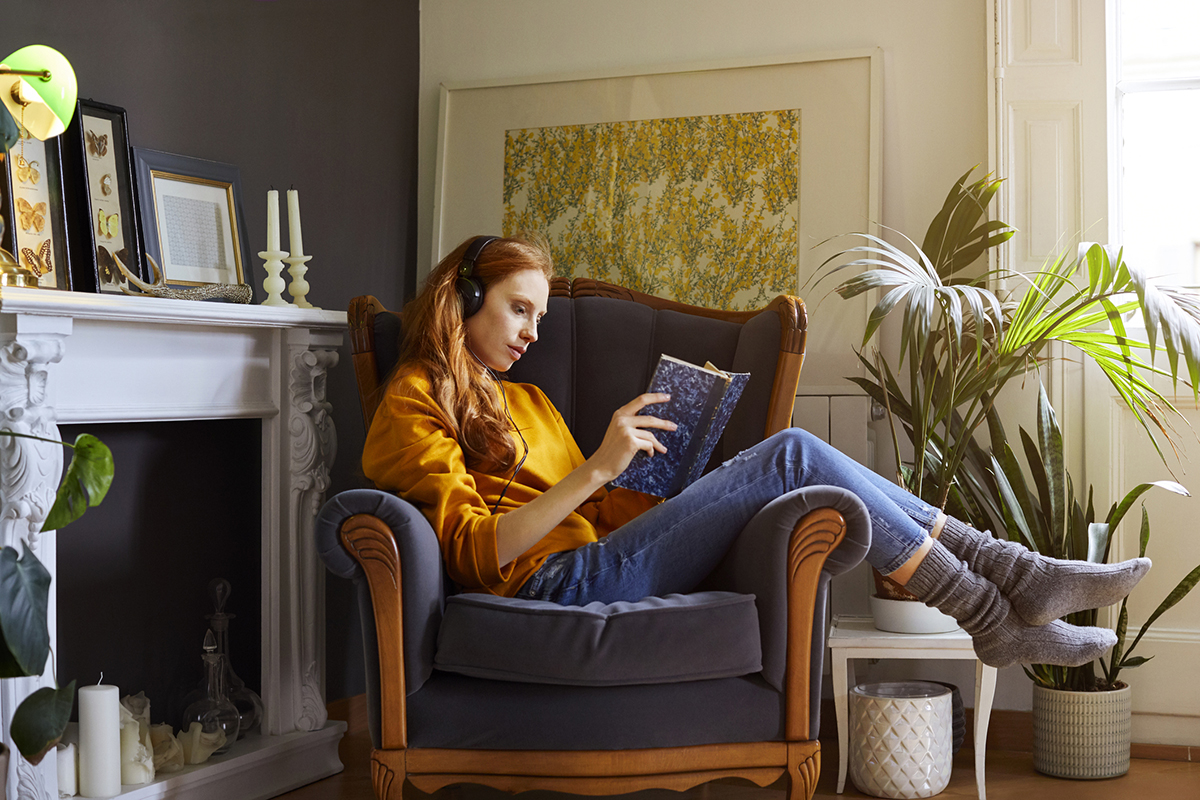 A woman lounging in a chair with a book
