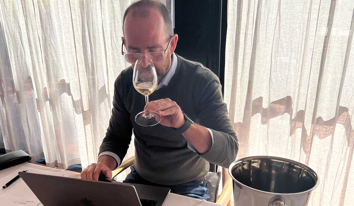 Campbell Mattinson tasting a glass of white wine