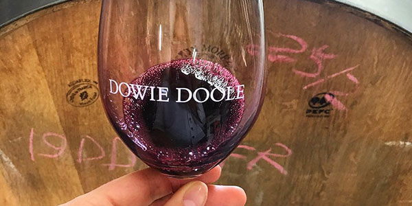 Dowie Doole red wine in glass with barrel in the background