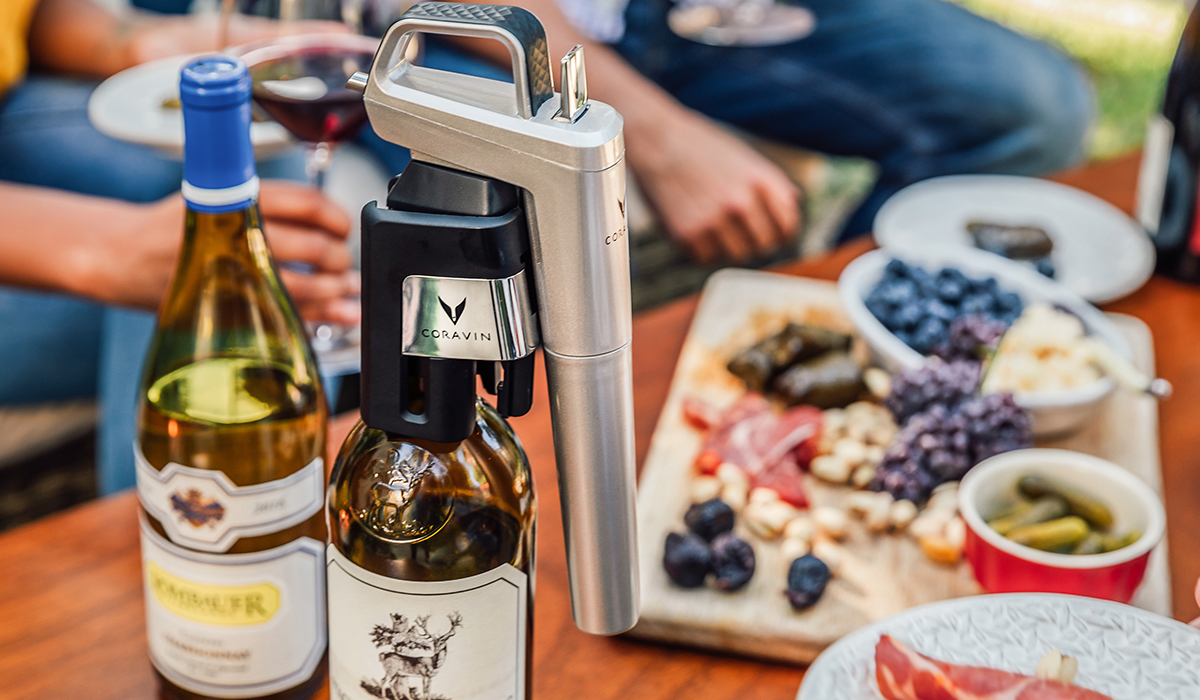 Coravin Model Six on a bottle next to a charcuterie plate