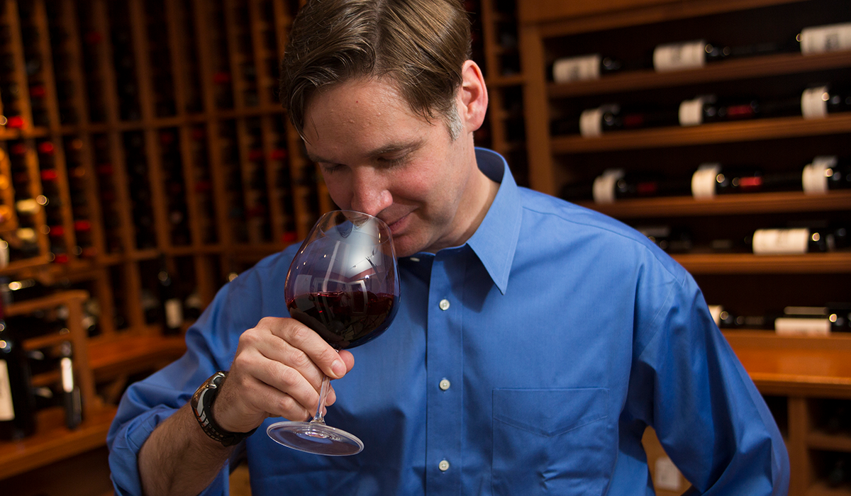 Greg Lambrecht smelling a glass of red wine