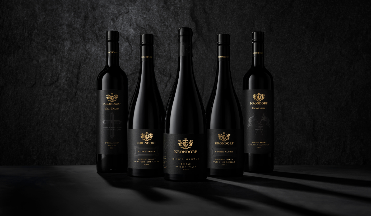 Five wine bottles posed against a black background