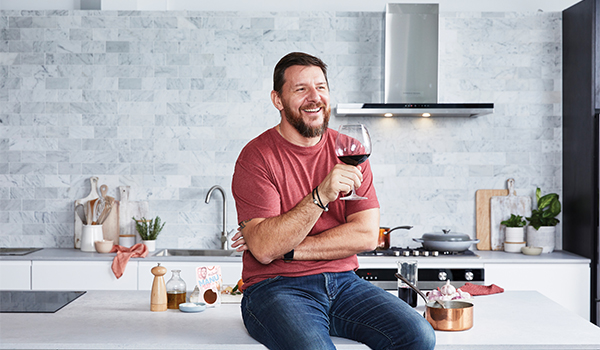 Chef Manu Feildel with a glass of wine