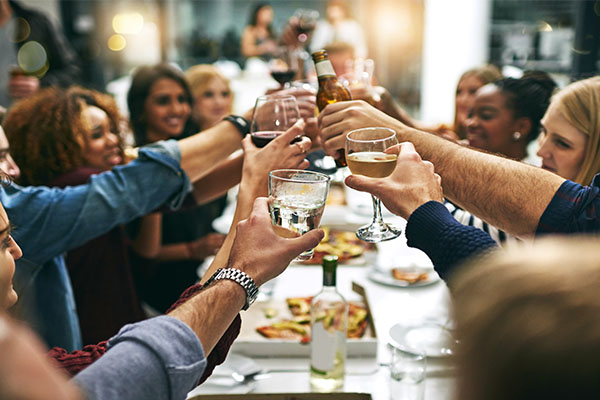 Group of friends using wine etiquette raising glasses at a party