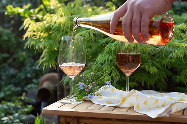 Pouring a glass of minimal intervention wine on a forest table