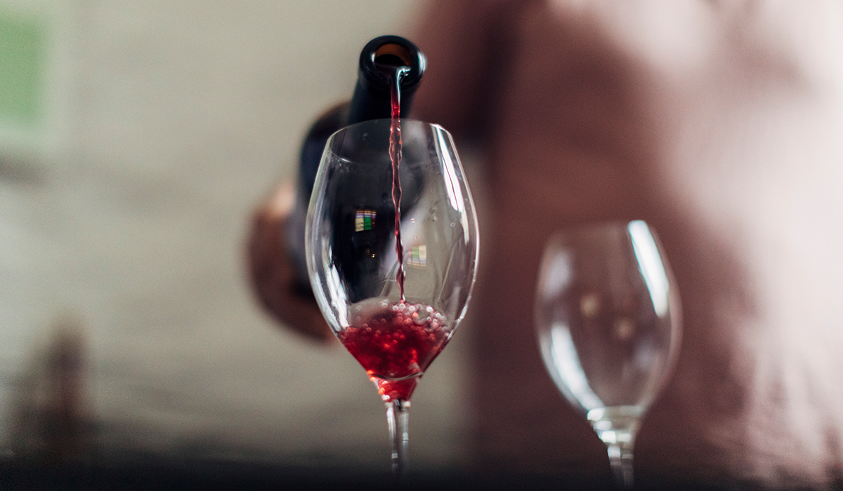 A glass of red wine being poured