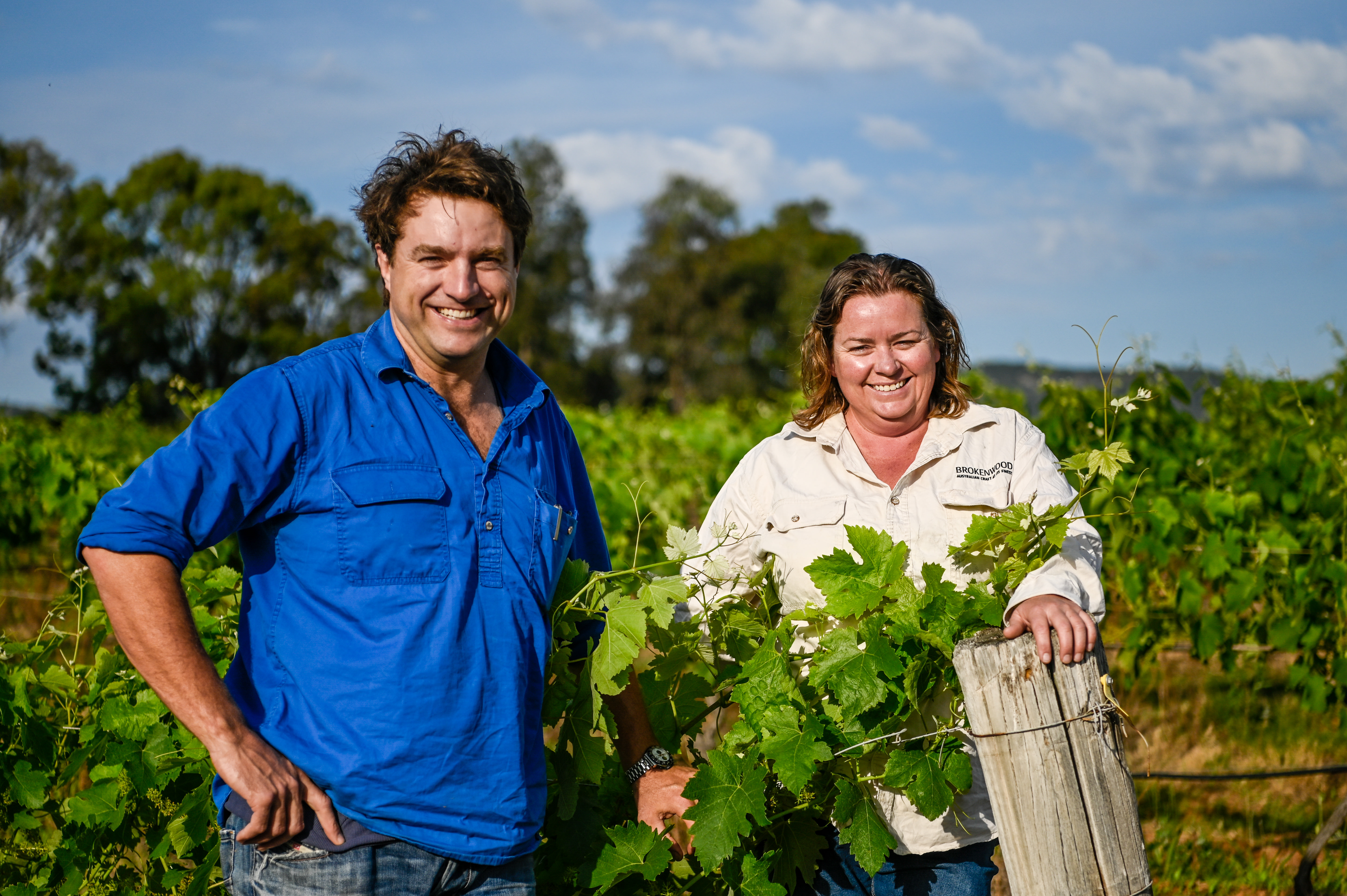 A man and woman posing in the vineyard 